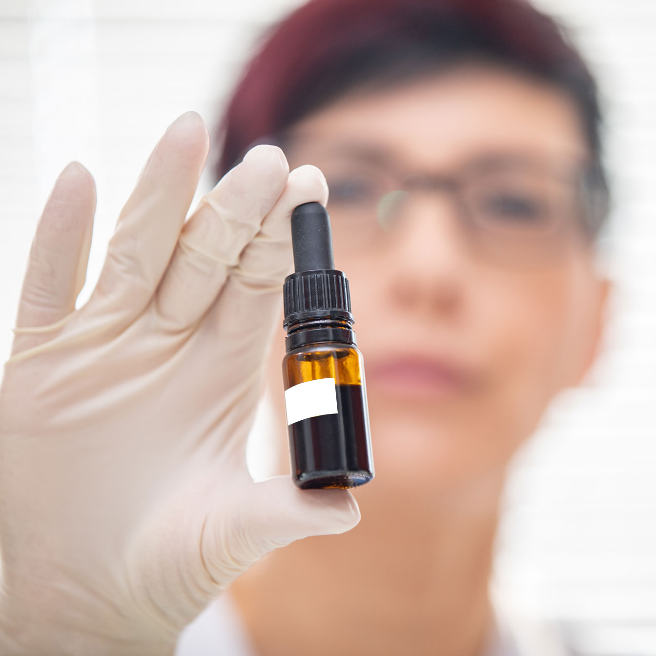 woman in lab coat holding bottle